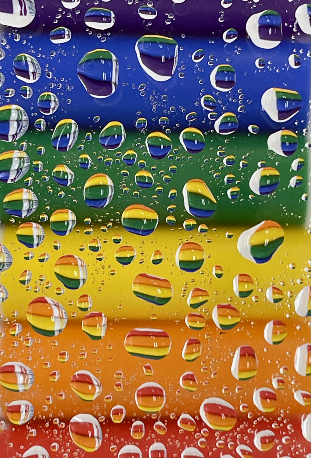 Rain drops on a translucent surface and a rainbow background.