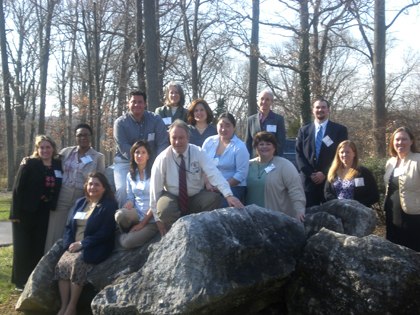 A group of service-learning fellows posing around a large rock formation at a Fellows Training Event